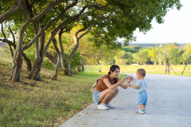 Anne bebekle oynuyor ve parka gidiyor.