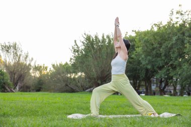 Parkta yoga yapan kadın.