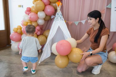 Anne balon kullanarak oğluyla oynuyor.