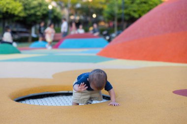 Yeşil doğa parkında mutlu oynayan sevimli bir bebek.