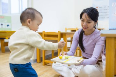 Anne evde bebeğiyle oynuyor.