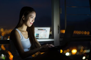 Evde dizüstü bilgisayar kullanan kadın