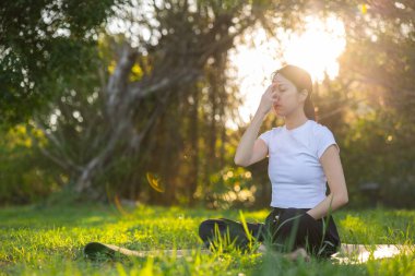 Sabah güneşinin altında nefes alma egzersizi yapan kadın.