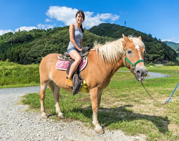 Asiatico giovane donna equitazione cavallo — Foto Stock