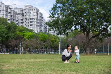 Anne oğluyla parkta eğleniyor.