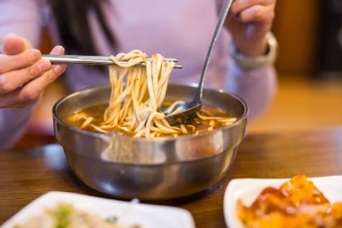 Tayvan usulü erişteli çorbanın tadını çıkaran bir kadın.