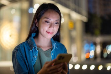 Cep telefonu şehirde geceleri kullanan kadın