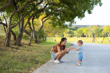 Anne, bebekle parkta vakit geçiriyor.