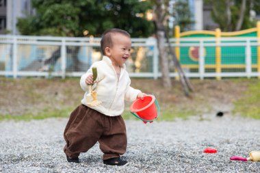 Bebeğimiz parkta oyuncak oyuncağıyla oynuyor.