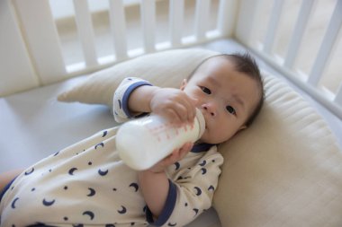 Tek başına süt içen sevimli bir bebek.