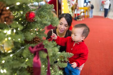 Annem Noel ağacına bakarken bebek taşıyor.