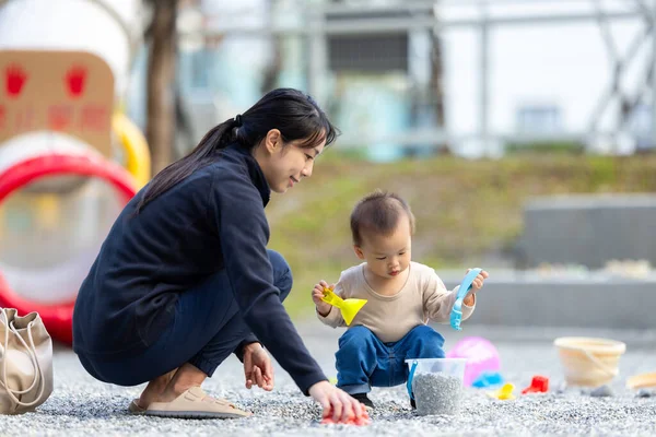 Genç anne bebeğe dışarıda oynamayı öğretiyor.