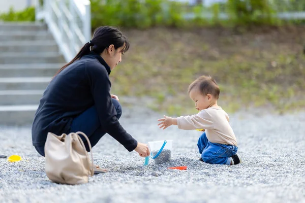 Anne açık hava aktivitesi sırasında çocuğuyla birlikte oturuyor.