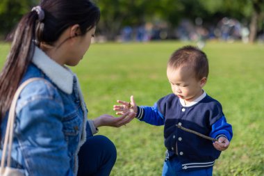 Anne ve bebek parkta birlikte oynuyorlar.