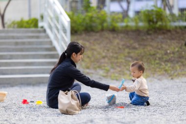 Küçük bebek annesiyle kazma taşı oynuyor.