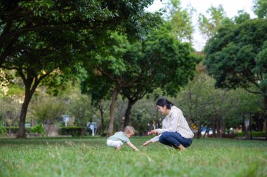 Anne ve oğul yeşil çimenlere bakın.