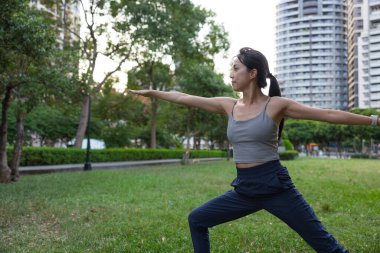 Şehir parkında yoga egzersizi yapan bir kadın.