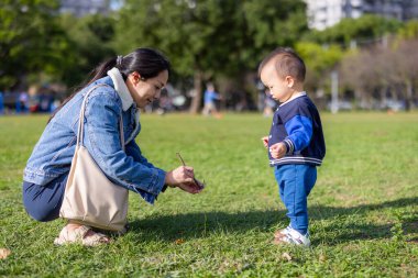 Anne parkta bebeğiyle oynuyor.