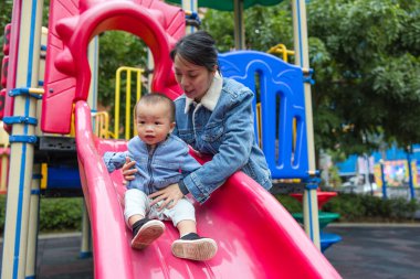 Anne bebek kaydırağını oyun parkına götür.