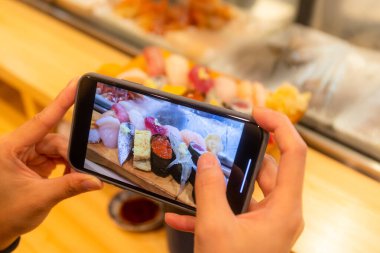Suşi çekmek için cep telefonu kullanmak.
