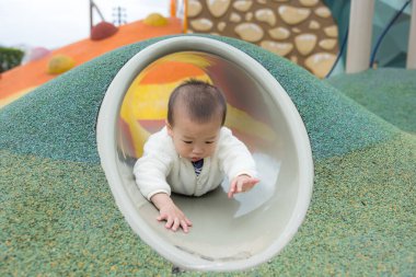 Çocuk parkındaki tünelde sürünen mutlu bebek