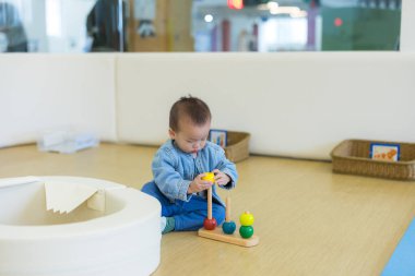 Bebek evin içinde oyuncaklarla oynuyor.