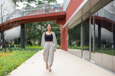 Sokak ortasında günlük yürüyüşler yapan bir kadın.