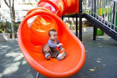 Bebek parkta slaytta oynuyor