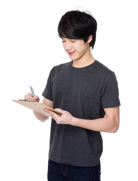 Young Man write on clipboard — Stock Photo, Image