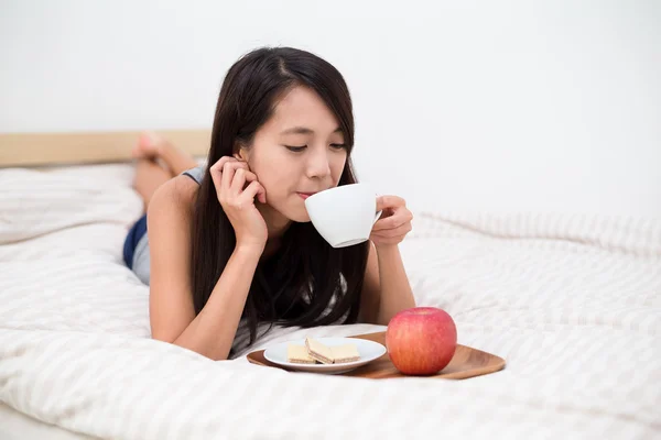Woman on bed drinking coffee — Stock Photo, Image