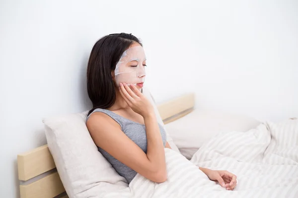 Kvinnan gör ansiktsbehandling papper mask — Stockfoto