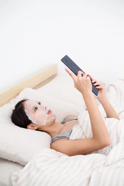 Wanita dengan masker wajah dan pc tablet — Stok Foto