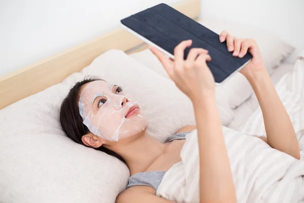 Wanita dengan masker wajah dan pc tablet — Stok Foto