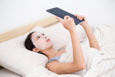 Tablet pc ve yüz maskesi kullanan kadın