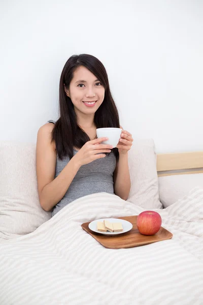 Женщина, завтракающая в постели — стоковое фото