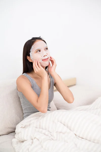 Vrouw met behulp van het gezicht masker — Stockfoto