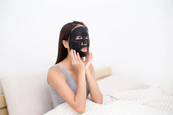 Donna utilizzando la maschera di carta foglio nero — Foto Stock