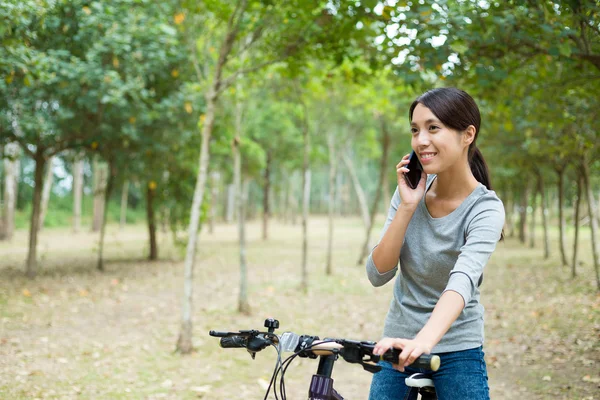 Woman talk to cellphone when cycling — Stock Photo, Image