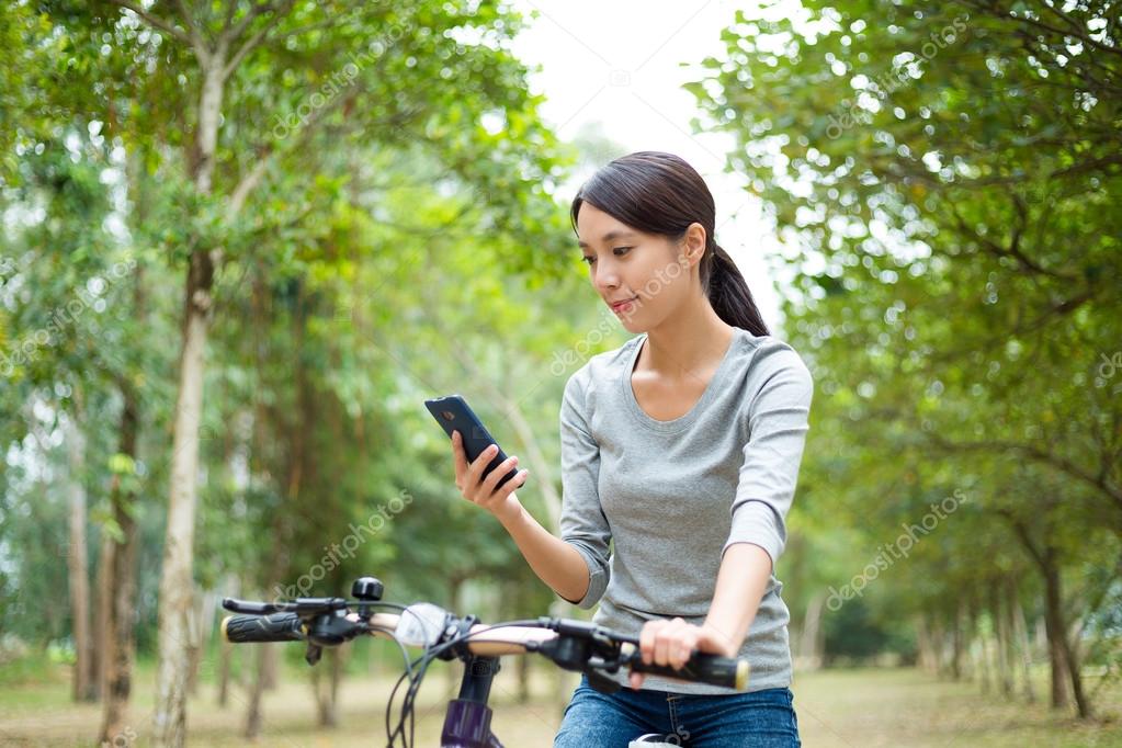 Woman on bike using mobile phone — Stock Photo © leungchopan #90577228