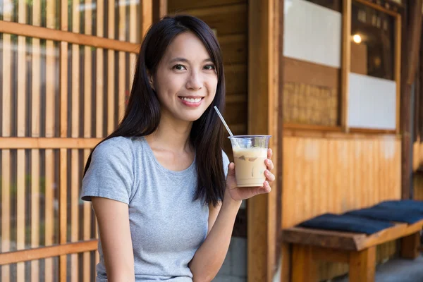 Молодая женщина пьет кофе со льдом — стоковое фото