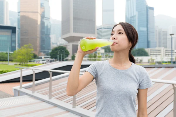 Sporty woman drinking vegetable beverage — Stock Photo, Image