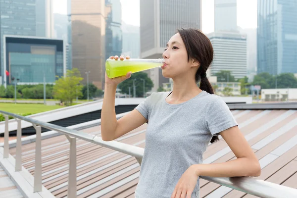 Sporty woman drinking vegetable beverage — Stock Photo, Image