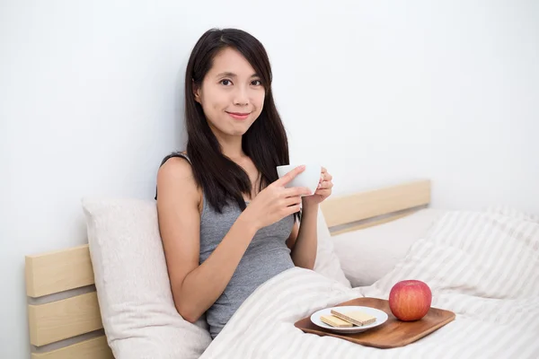 Frau frühstückt morgens im Bett — Stockfoto