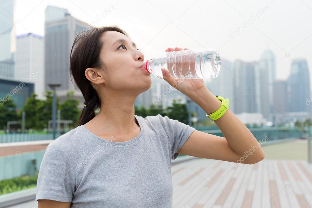young sporty woman drinking water