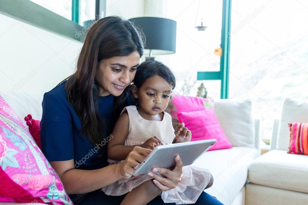 Indian girl play tablet pc with mother
