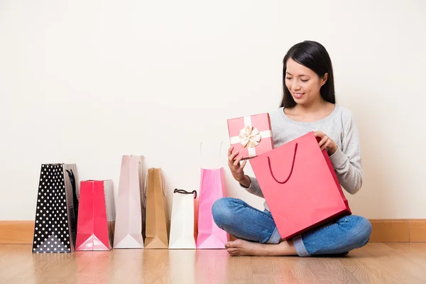 Frau nimmt Geschenk aus Einkaufstasche — Stockfoto