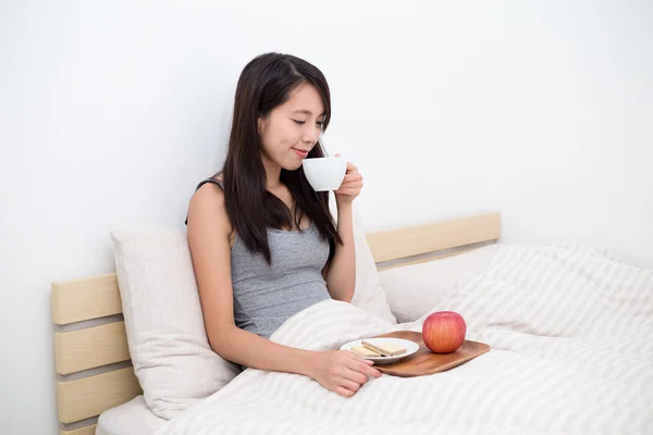 침대에서 아침을 먹는 여자 — 스톡 사진