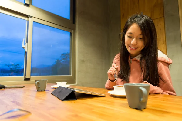 Femme ayant du pudding et regardant la tablette — Photo