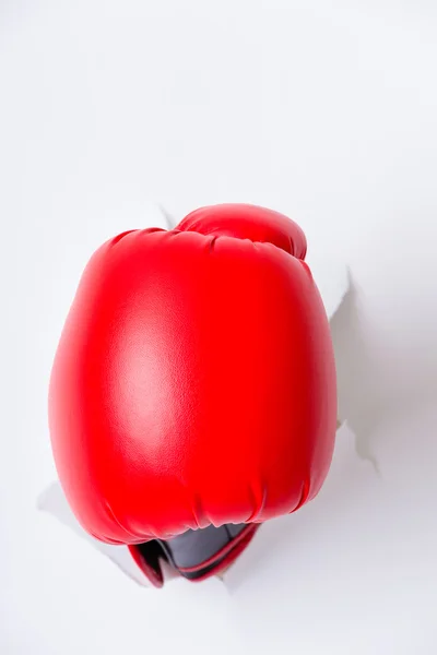 Hand in boxing glove through paper hole — Stock Photo, Image