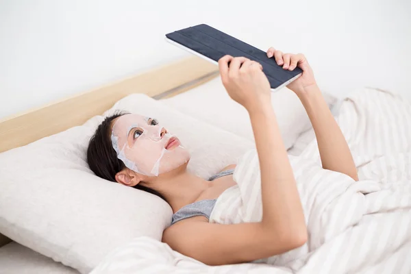 Vrouw met gezichts masker gebruiken, tablet pc — Stockfoto